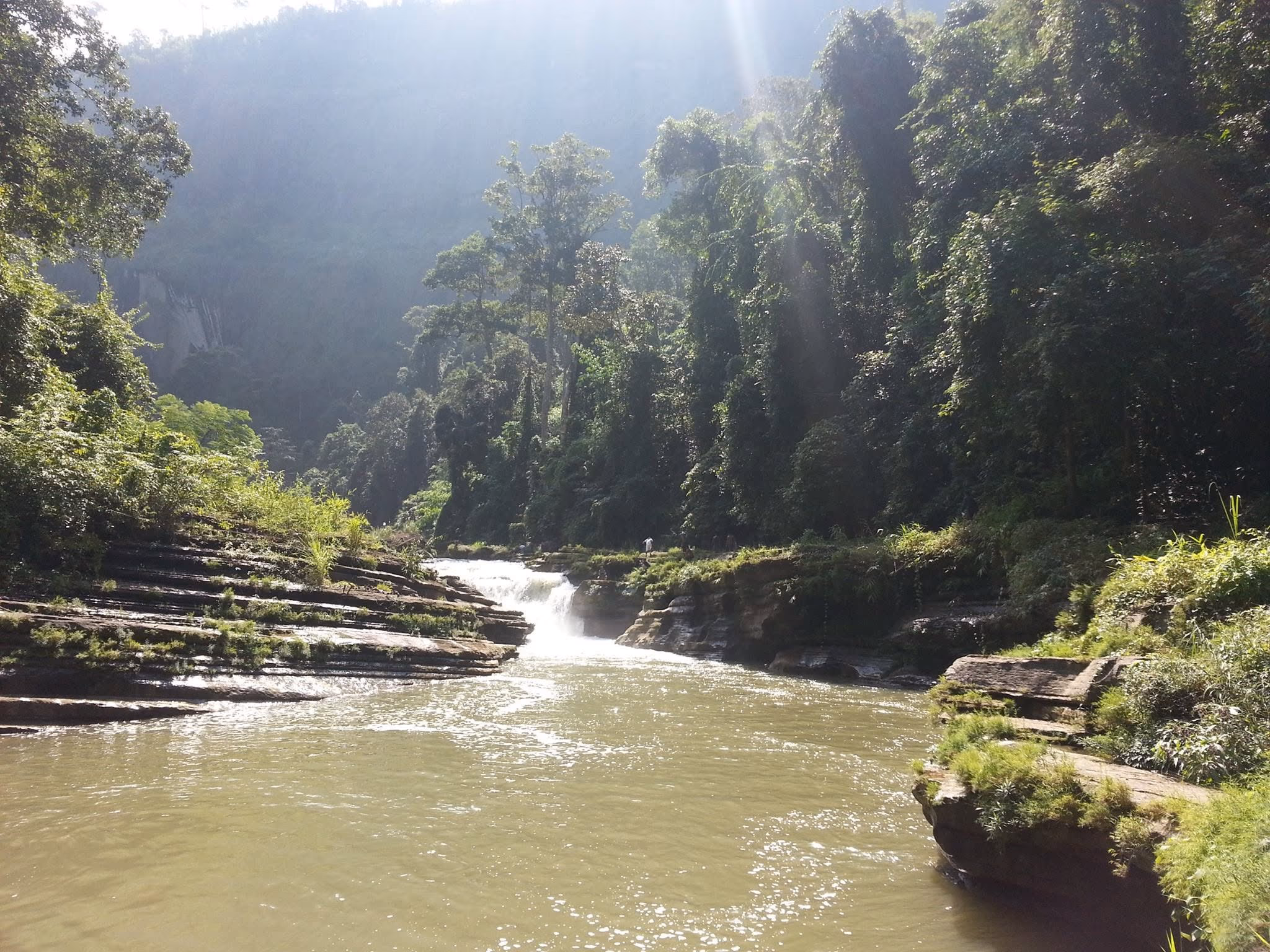 Amiakhum Falls seen through forest canopy in midday sun, Bandarban